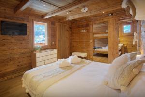 a bedroom with a large bed in a log cabin at La Ferme du Gran Shan - OVO Network in Les Villards-sur-Thônes