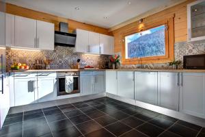 a kitchen with white cabinets and a window at Chalet Carter - OVO Network in Saint-Jean-de-Sixt +40 photos