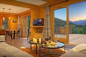 a living room with a couch and a table with wine glasses at Chalet Carter - OVO Network in Saint-Jean-de-Sixt