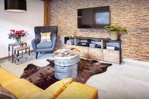 a living room with a tv on a brick wall at Chalet Carter - OVO Network in Saint-Jean-de-Sixt