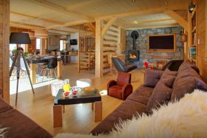 ein Wohnzimmer mit einem Sofa und einem Tisch in der Unterkunft Chalet Crechoua - OVO Network in La Giettaz