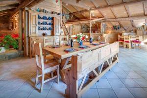 uma cozinha com uma grande mesa de madeira e cadeiras em La Ferme à Juju - OVO Network em La Clusaz