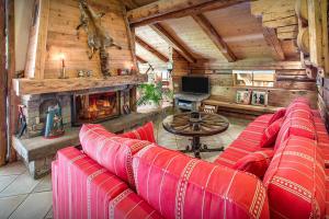 uma sala de estar com um sofá vermelho e uma lareira em La Ferme à Juju - OVO Network em La Clusaz