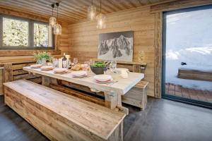 a dining room with a table and a large window at Chalet Charmar - OVO Network in La Clusaz