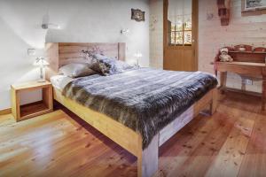 a bedroom with a large bed and a wooden floor at La Ferme à Juju - OVO Network in La Clusaz