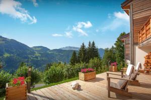 a dog laying on a wooden deck with mountains in the background at Chalet Charmar - OVO Network in La Clusaz