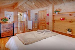 a bedroom with a large bed in a wooden room at Chalet des Mômes - OVO Network in Le Grand-Bornand +13 photos