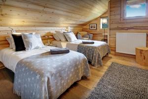 1 dormitorio con 2 camas en una cabaña de madera en Chalet de Paul et Marie - OVO Network, en Manigod