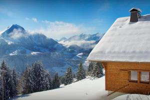 a cabin in the snow with a view of mountains at Chalet de Paul et Marie - OVO Network in Manigod