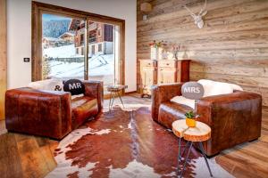 two leather couches in a room with a window at Chalet Alti - OVO Network in Le Grand-Bornand