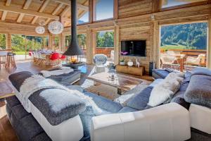 a living room with a couch and a table at Chalet Alti - OVO Network in Le Grand-Bornand