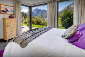 a bedroom with a bed and a large window at Chalet de Rollon - OVO Network in Thônes