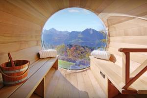 an inside view of a sauna with an oval window at La Grange à L'Ours - OVO Network in Manigod