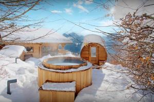a hot tub in the snow next to a building at La Grange à L'Ours - OVO Network in Manigod