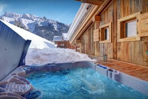 a hot tub in a building with snow at Chalet Les Brévins - OVO Network in Manigod