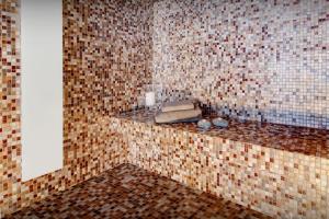 a bathroom with brown tiled walls and a counter with a sink at Chalet Les Brévins - OVO Network in Manigod