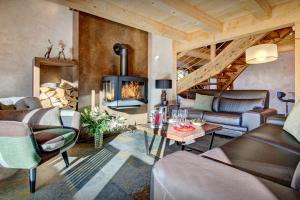 a living room with a couch and a fireplace at Chalet Les Brévins - OVO Network in Manigod