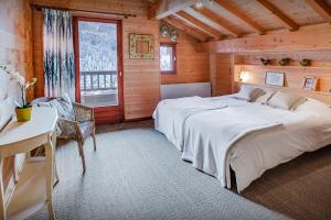 a bedroom with a large bed in a wooden cabin at Chalet Les Houlottes - OVO Network in Manigod
