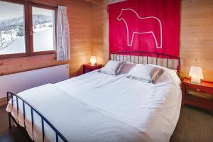 1 dormitorio con 1 cama con un cuadro de caballos en la pared en Chalet Les Houlottes - OVO Network, en Manigod