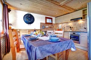 a kitchen with a table and a clock on the wall at Chalet Le Petit Mazot - OVO Network in La Clusaz