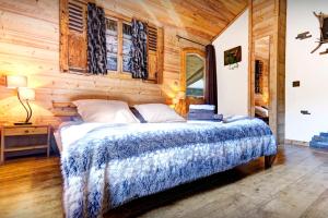 a bedroom with a bed and a wooden wall at Chalet Le Petit Mazot - OVO Network in La Clusaz