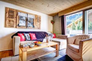a living room with a couch and a table at Chalet Le Petit Mazot - OVO Network in La Clusaz
