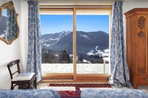 a bedroom with a window with a mountain view at Chalet Polanka - OVO Network in Saint-Jean-de-Sixt