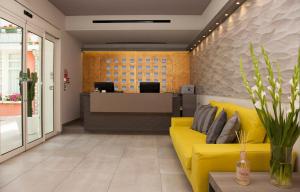 an office with a yellow couch in the lobby at Hotel Helvetia in Lido di Jesolo