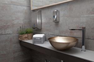 a bathroom with a wooden bowl sink on a counter at Hotel Helvetia in Lido di Jesolo +40 photos