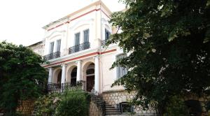 una casa blanca con una escalera delante en The Pitoulis Mansion, en Igoumenitsa