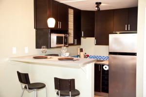 a kitchen with black cabinets and a white refrigerator at The Flagstone Boutique Inn & Suites in Kanab