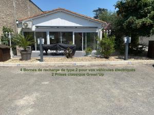 a sign in front of a building with a table at Logis Hôtel L'Oliveraie in Cognac