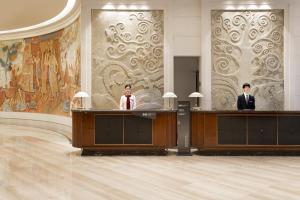 two men in suits are standing in a room at Crowne Plaza Nanchang Riverside, an IHG Hotel in Nanchang
