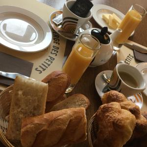 a table topped with a plate of bread and orange juice at Auberge Des Petits in Saint-Igny-de-Vers