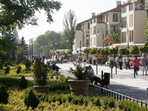 a group of people sitting on benches in a park at ApartNet Apartamenty przy Promenadzie in Świnoujście