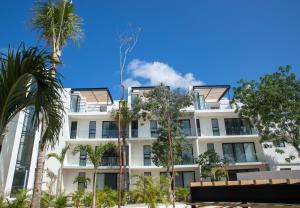 un edificio bianco con palme di fronte di The Panoramic By Xperience Hotels a Tulum