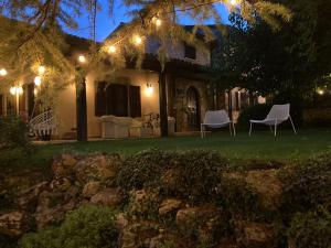 a house with two chairs in the yard at night at Casale Dolci Dimore in Massa Martana