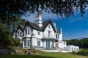 a large white house with a black roof at Penally Manor - Luxurious Manor House - Tenby in Penally
