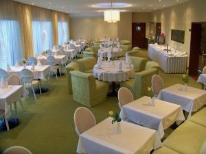 un comedor con mesas y sillas y mesas y sillas blancas en Hotel Gniecki Gdansk en Przejazdowo