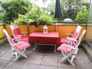 a table and four chairs and an umbrella on a patio at City terrace-apartment in Vienna