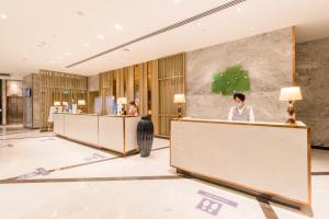 a lobby with a woman wearing a face mask at Holiday Inn Chandigarh Zirakpur, an IHG Hotel in Chandīgarh