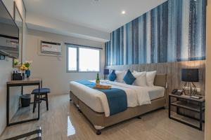 a bedroom with a large bed with blue curtains at Bayfront Hotel Cebu Capitol Site in Cebu City