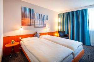 a hotel room with two beds and two lamps at Hotel Metropol Basel in Basel
