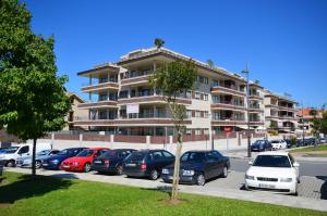 a parking lot with cars parked in front of a building at FLATSELECT Decanelas in Portonovo