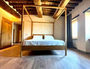 1 cama con marco de madera en una habitación en Palazzolo Resort - Anghiari, en Anghiari
