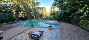 una piscina en un patio trasero con mesa y sillas en Un espacio único en un entorno de naturaleza, en Navacerrada