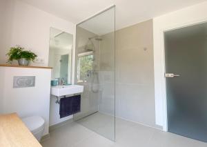 ein Bad mit einer Dusche, einem WC und einem Waschbecken in der Unterkunft Stilvolles Apartment mit Bergblick-Hütte und Garten in Wolfratshausen