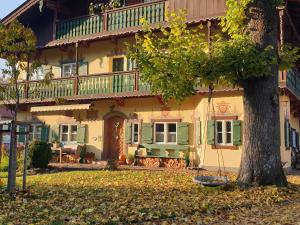 a large house with a tree in front of it at Landhaus SeenSucht in Schliersee