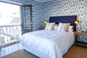 a bedroom with a large bed with blue and white wallpaper at Villa Le Roc Kleinmond Accommodation in Kleinmond