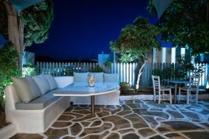 a patio with a couch and a table and chairs at Hotel Iris in Naousa